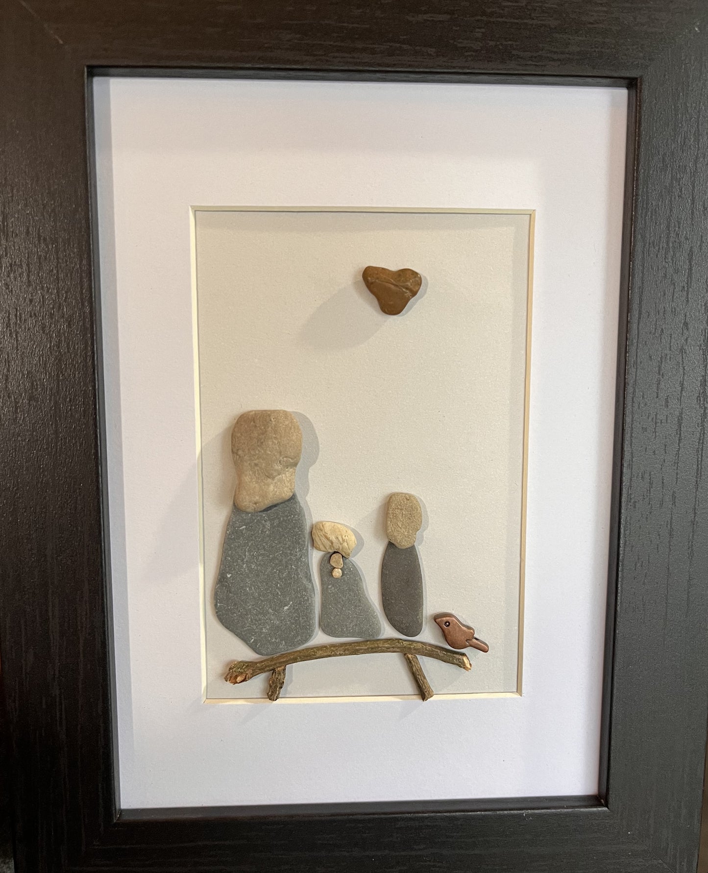 pebble art mother and daughters sitting on a bench with a bird